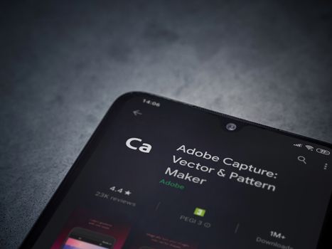 Lod, Israel - July 8, 2020: Adobe Capture - Vector and Pattern Maker app play store page on the display of a black mobile smartphone on a dark marble stone background. Top view flat lay with copy space.
