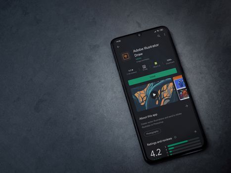 Lod, Israel - July 8, 2020: Adobe Illustrator Draw app play store page on the display of a black mobile smartphone on a dark marble stone background. Top view flat lay with copy space.