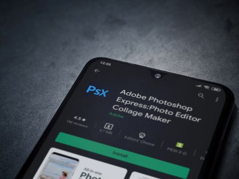 Lod, Israel - July 8, 2020: Adobe Photoshop Express Photo Editor app play store page on the display of a black mobile smartphone on a dark marble stone background. Top view flat lay with copy space.