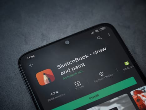 Lod, Israel - July 8, 2020: Autodesk SketchBook - draw and paint app play store page on the display of a black mobile smartphone on a dark marble stone background. Top view flat lay with copy space.