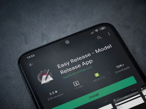Lod, Israel - July 8, 2020: Easy Release Pro - Model Release app play store page on the display of a black mobile smartphone on a dark marble stone background. Top view flat lay with copy space. 