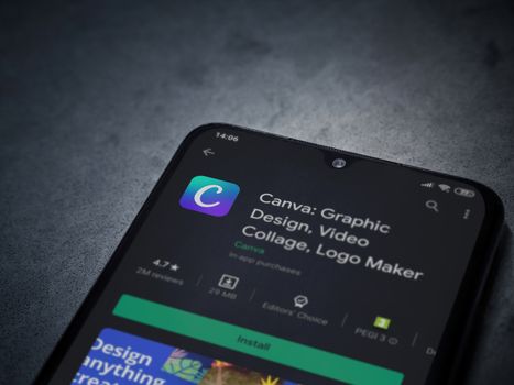 Lod, Israel - July 8, 2020: Canva - Graphic Design app play store page on the display of a black mobile smartphone on a dark marble stone background. Top view flat lay with copy space. 