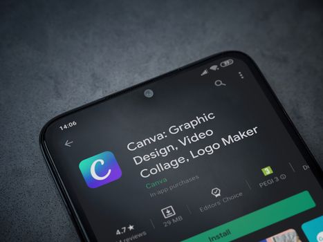 Lod, Israel - July 8, 2020: Canva - Graphic Design app play store page on the display of a black mobile smartphone on a dark marble stone background. Top view flat lay with copy space. 