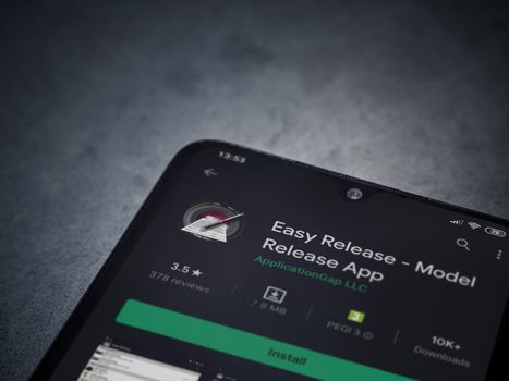 Lod, Israel - July 8, 2020: Easy Release Pro - Model Release app play store page on the display of a black mobile smartphone on a dark marble stone background. Top view flat lay with copy space. 