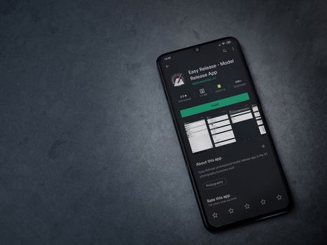 Lod, Israel - July 8, 2020: Easy Release Pro - Model Release app play store page on the display of a black mobile smartphone on a dark marble stone background. Top view flat lay with copy space. 
