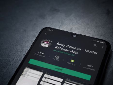Lod, Israel - July 8, 2020: Easy Release Pro - Model Release app play store page on the display of a black mobile smartphone on a dark marble stone background. Top view flat lay with copy space. 