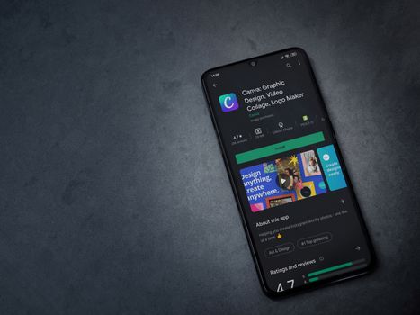Lod, Israel - July 8, 2020: Canva - Graphic Design app play store page on the display of a black mobile smartphone on a dark marble stone background. Top view flat lay with copy space. 