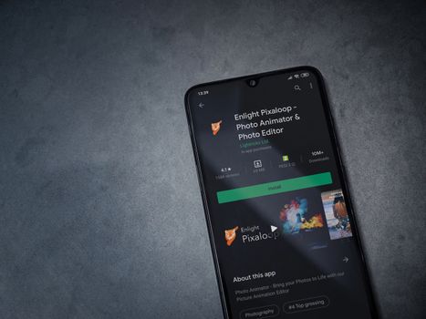 Lod, Israel - July 8, 2020: Enlight Pixaloop app play store page on the display of a black mobile smartphone on a dark marble stone background. Top view flat lay with copy space.