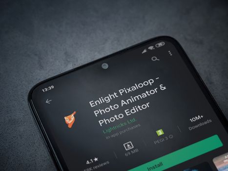 Lod, Israel - July 8, 2020: Enlight Pixaloop app play store page on the display of a black mobile smartphone on a dark marble stone background. Top view flat lay with copy space.