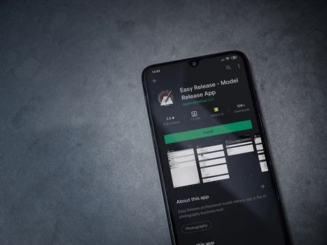 Lod, Israel - July 8, 2020: Easy Release Pro - Model Release app play store page on the display of a black mobile smartphone on a dark marble stone background. Top view flat lay with copy space. 
