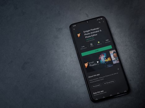 Lod, Israel - July 8, 2020: Enlight Pixaloop app play store page on the display of a black mobile smartphone on a dark marble stone background. Top view flat lay with copy space.
