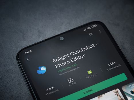 Lod, Israel - July 8, 2020: Enlight Quickshot app play store page on the display of a black mobile smartphone on a dark marble stone background. Top view flat lay with copy space.