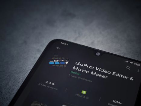 Lod, Israel - July 8, 2020: GoPro - Video Editor and Movie Maker app play store page on the display of a black mobile smartphone on a dark marble stone background. Top view flat lay with copy space.