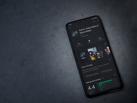 Lod, Israel - July 8, 2020: GoPro - Video Editor and Movie Maker app play store page on the display of a black mobile smartphone on a dark marble stone background. Top view flat lay with copy space.