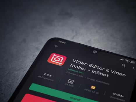 Lod, Israel - July 8, 2020: InShot - Video Editor and Movie Maker app play store page on the display of a black mobile smartphone on a dark marble stone background. Top view flat lay with copy space.