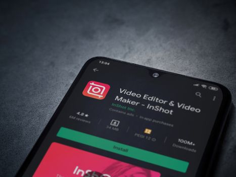 Lod, Israel - July 8, 2020: InShot - Video Editor and Movie Maker app play store page on the display of a black mobile smartphone on a dark marble stone background. Top view flat lay with copy space.