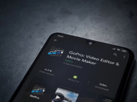 Lod, Israel - July 8, 2020: GoPro - Video Editor and Movie Maker app play store page on the display of a black mobile smartphone on a dark marble stone background. Top view flat lay with copy space.
