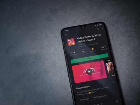 Lod, Israel - July 8, 2020: InShot - Video Editor and Movie Maker app play store page on the display of a black mobile smartphone on a dark marble stone background. Top view flat lay with copy space.