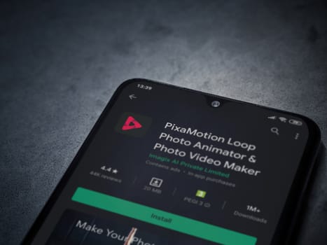 Lod, Israel - July 8, 2020: PixaMotion app play store page on the display of a black mobile smartphone on a dark marble stone background. Top view flat lay with copy space.