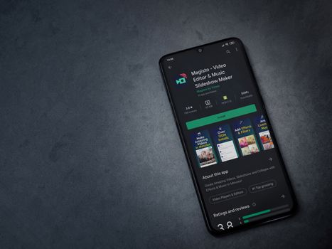 Lod, Israel - July 8, 2020: Magisto - Video Editor and Movie Maker app play store page on the display of a black mobile smartphone on a dark marble stone background. Top view flat lay with copy space.