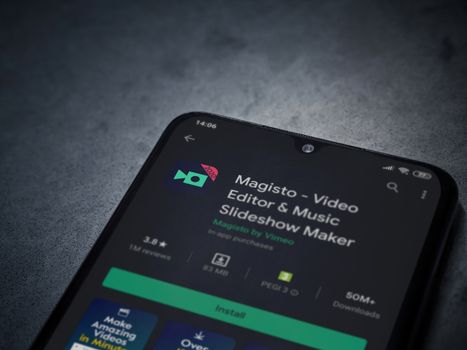 Lod, Israel - July 8, 2020: Magisto - Video Editor and Movie Maker app play store page on the display of a black mobile smartphone on a dark marble stone background. Top view flat lay with copy space.