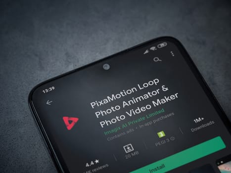 Lod, Israel - July 8, 2020: PixaMotion app play store page on the display of a black mobile smartphone on a dark marble stone background. Top view flat lay with copy space.