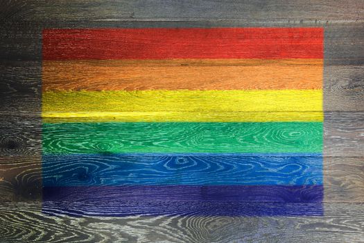 A Gay pride rainbow flag on rustic old wood surface background