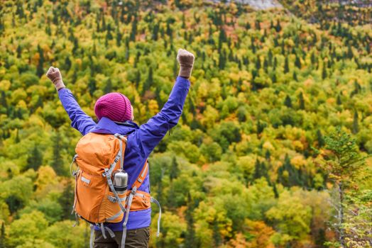 Success winner woman hiker cheering of happiness and joy on mountain in autumn nature. Hiking person happy of life goal achievement arms up raised as winning gesture.