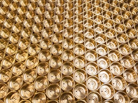 an abstract perspective industrial close-up background of shiny brass metal threaded hexagonal fitting parts.