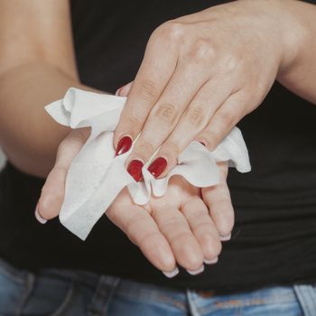 Young woman clean hands with wet wipes