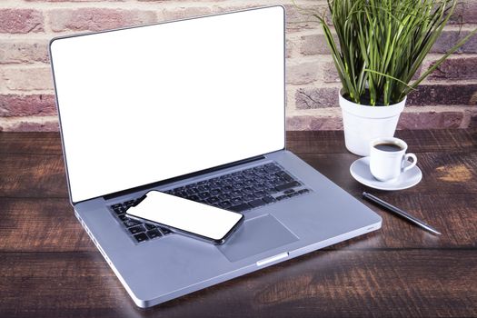 New SmartPhone on laptop keyboard over table.