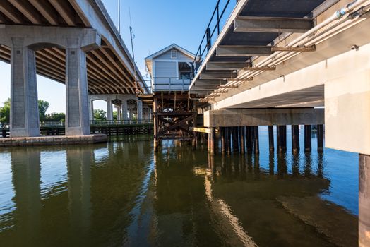 A wide angle photo looking up at a Shark river overpass with a drawbridge station in Belmar, NJ.