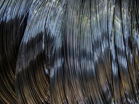 Closeup background of metal wire roll in silver color. Building material. Texture with selective focus and blur.