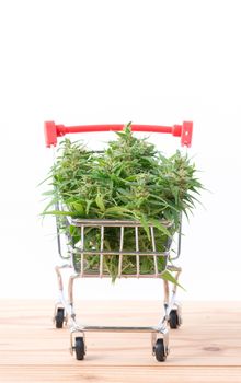 fresh marijuana flower in shopping cart on table