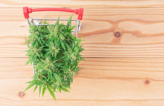 fresh marijuana flower in shopping cart on table