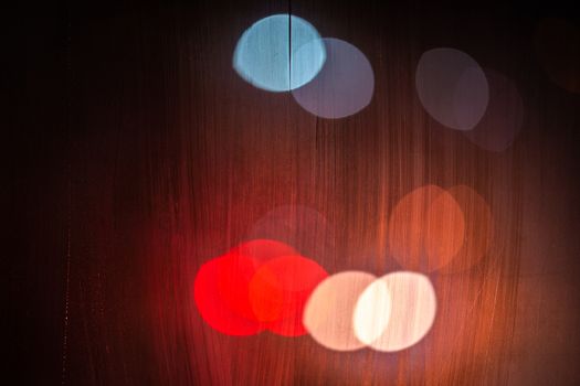 night street lights bokeh through wet glass, close-up with selective focus.