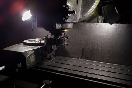 old manual milling machine in noir lighting style closeup with selective focus.