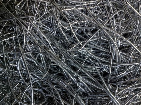 Long curly aluminium chips pattern background with selective focus.