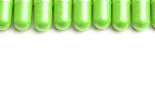row of ufo green color organic capsules isolated on white background closeup with selective focus.