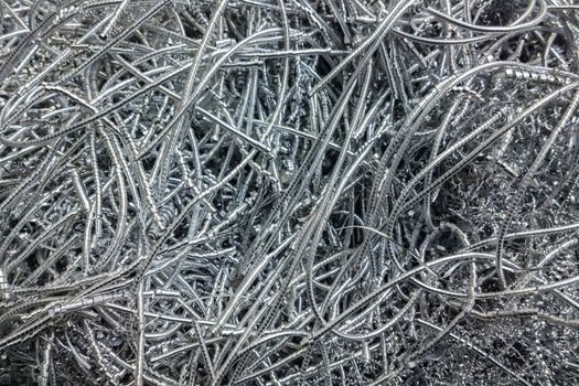 Long curly aluminium chips pattern background with selective focus.