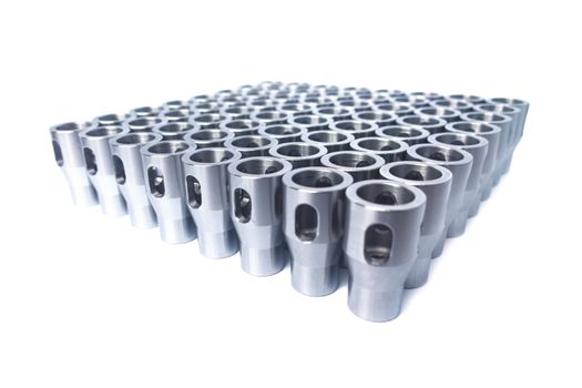 Shiny steel parts after cnc turning, drilling and machining isolated on white background with selective focus.