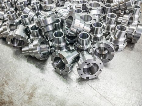 Shiny steel parts after cnc turning, drilling and machining on steel surface selective focus composition background.