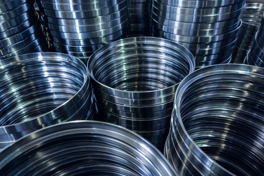 industrial manufacturing background of columns of shiny metal rings after cnc turning operation. Selective focus technique.