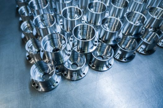 Shiny metal parts after cnc turning, drilling and machining on steel surface with selective focus for industrial background.
