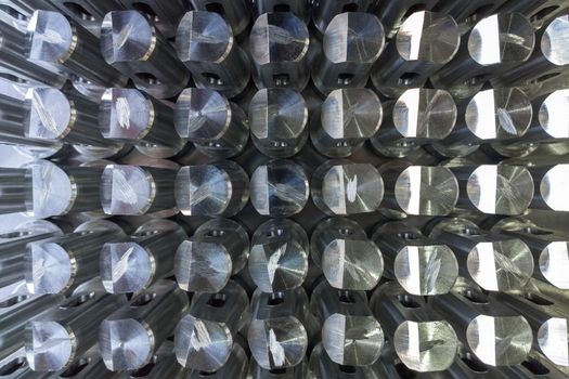 Batch of shiny metal parts after cnc turning and milling top-down view with selective focus