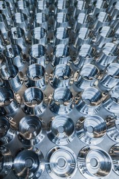 a batch of shiny metal cnc aerospace parts production - close-up with selective focus for industrial full frame background.