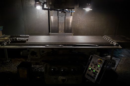 old manual milling machine in noir lighting style closeup with selective focus.