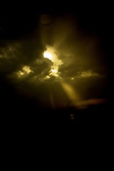 Single car travels on dark road. Mystic light in the clouds