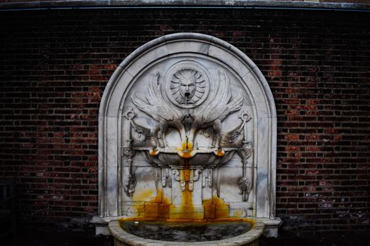A Flowing Ornate Marble Fountain With Rust Stains From Years of Use