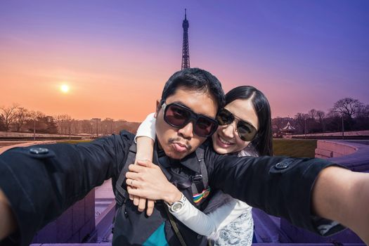 Young Couple Tourists selfie with mobile phone near the Eiffel tower in Paris, France